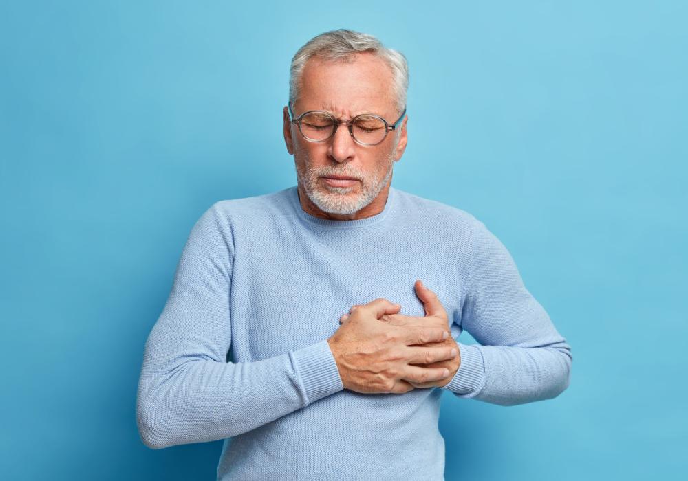 Man clutching his chest in distress, possibly experiencing a heart attack.