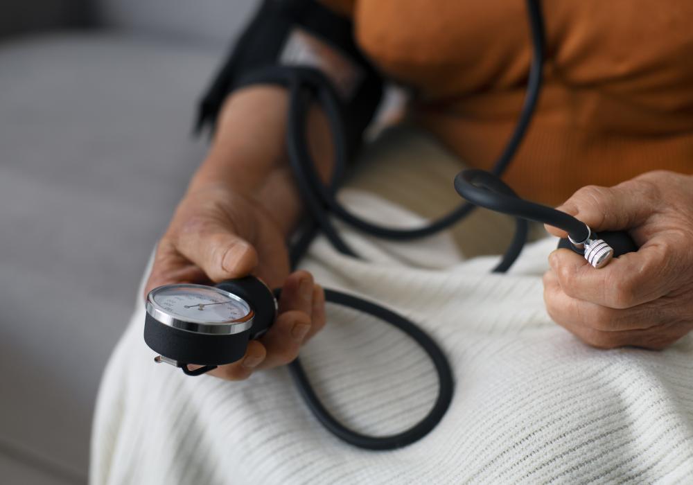 Doctor measuring a man's blood pressure with a sphygmomanometer in a clinical setting.