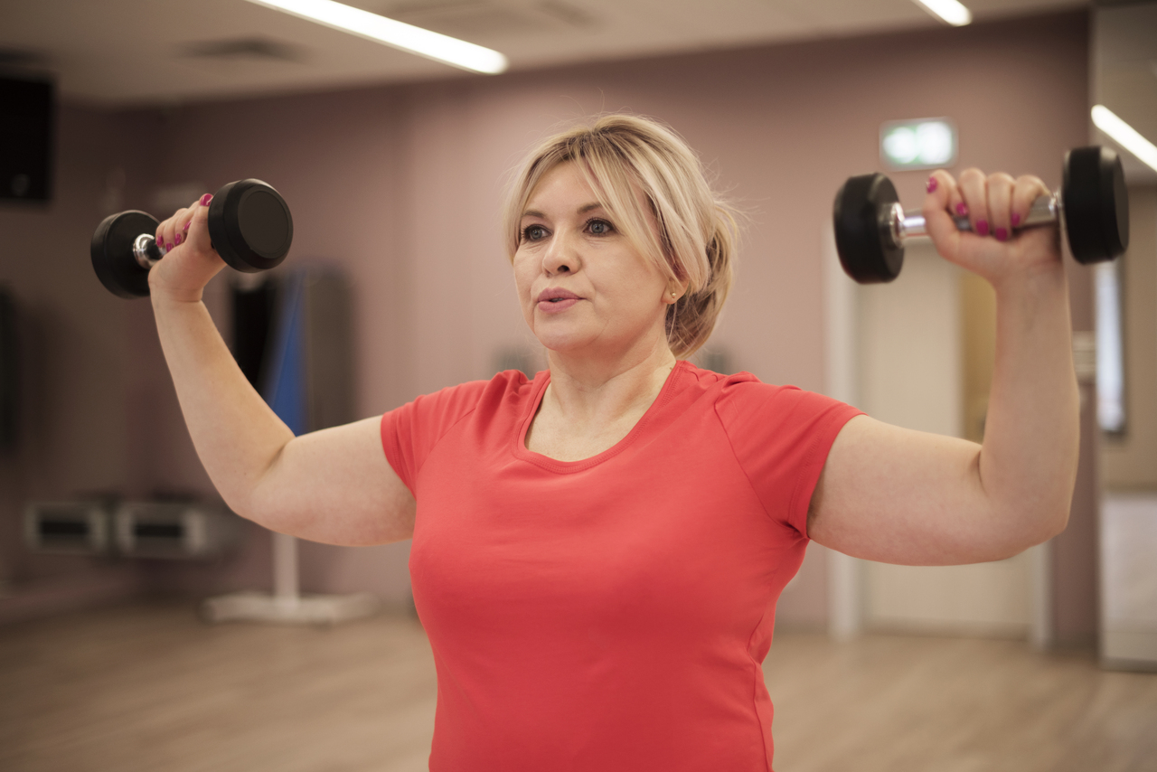A senior woman who takes RAD-140 (Testolone) working out with dumbbells
