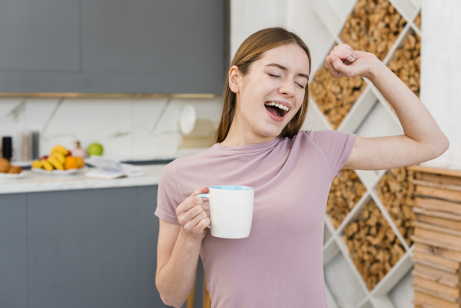 yawning woman holding cup kitchen