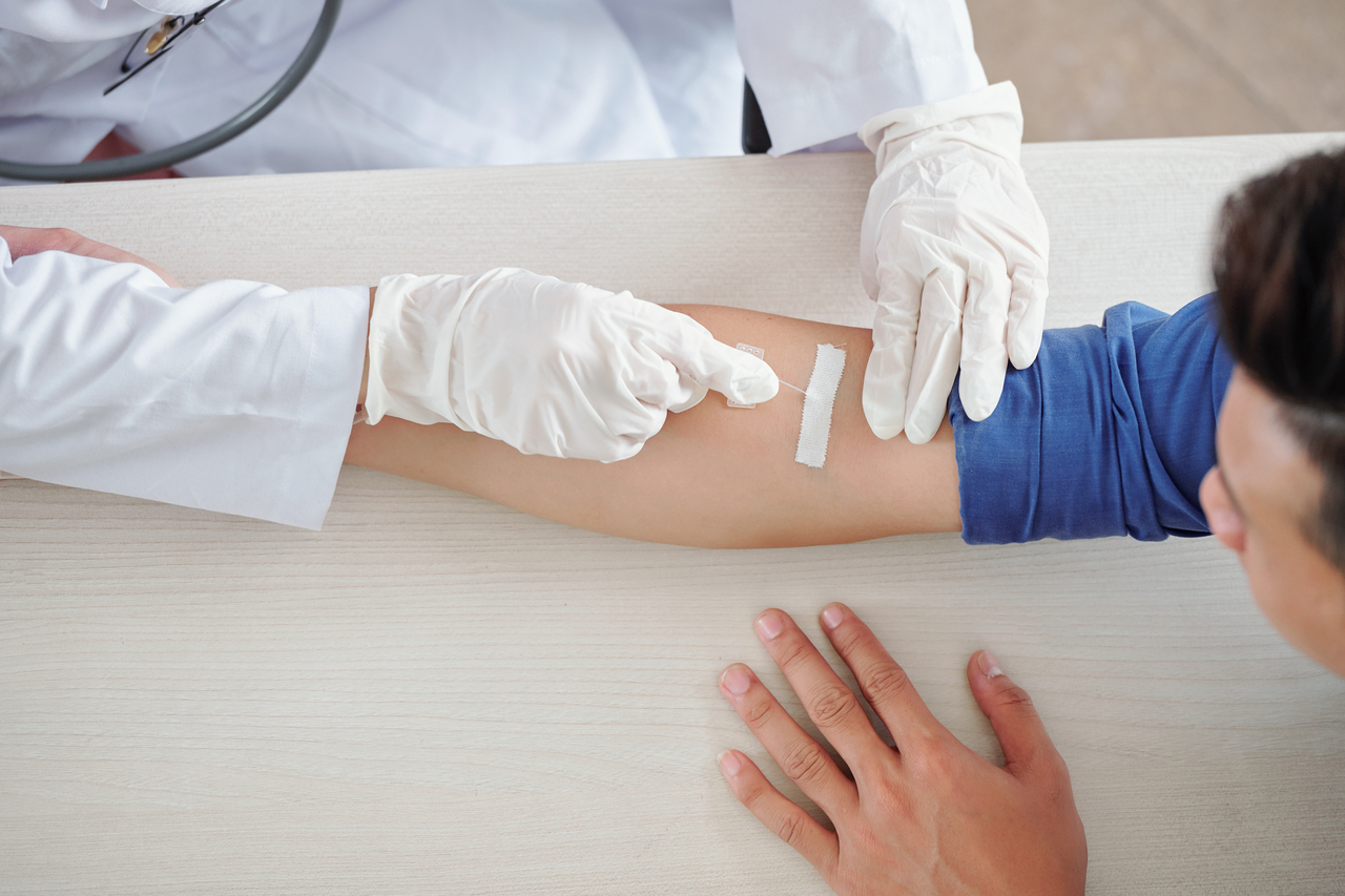 A man with night sweats taking a blood test to inspect low testosterone