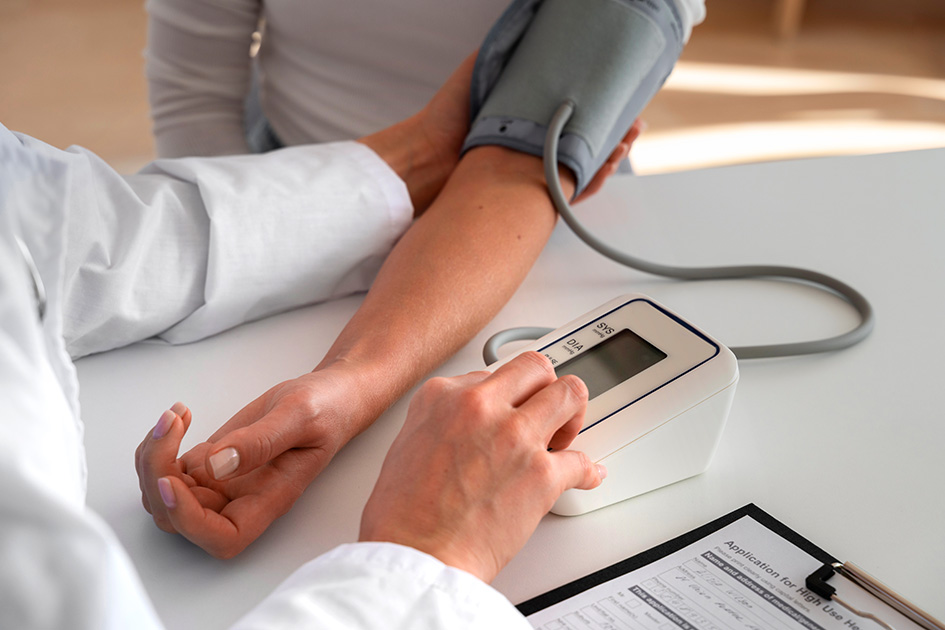 A doctor in a medical setting measuring a man's blood pressure using a sphygmomanometer.